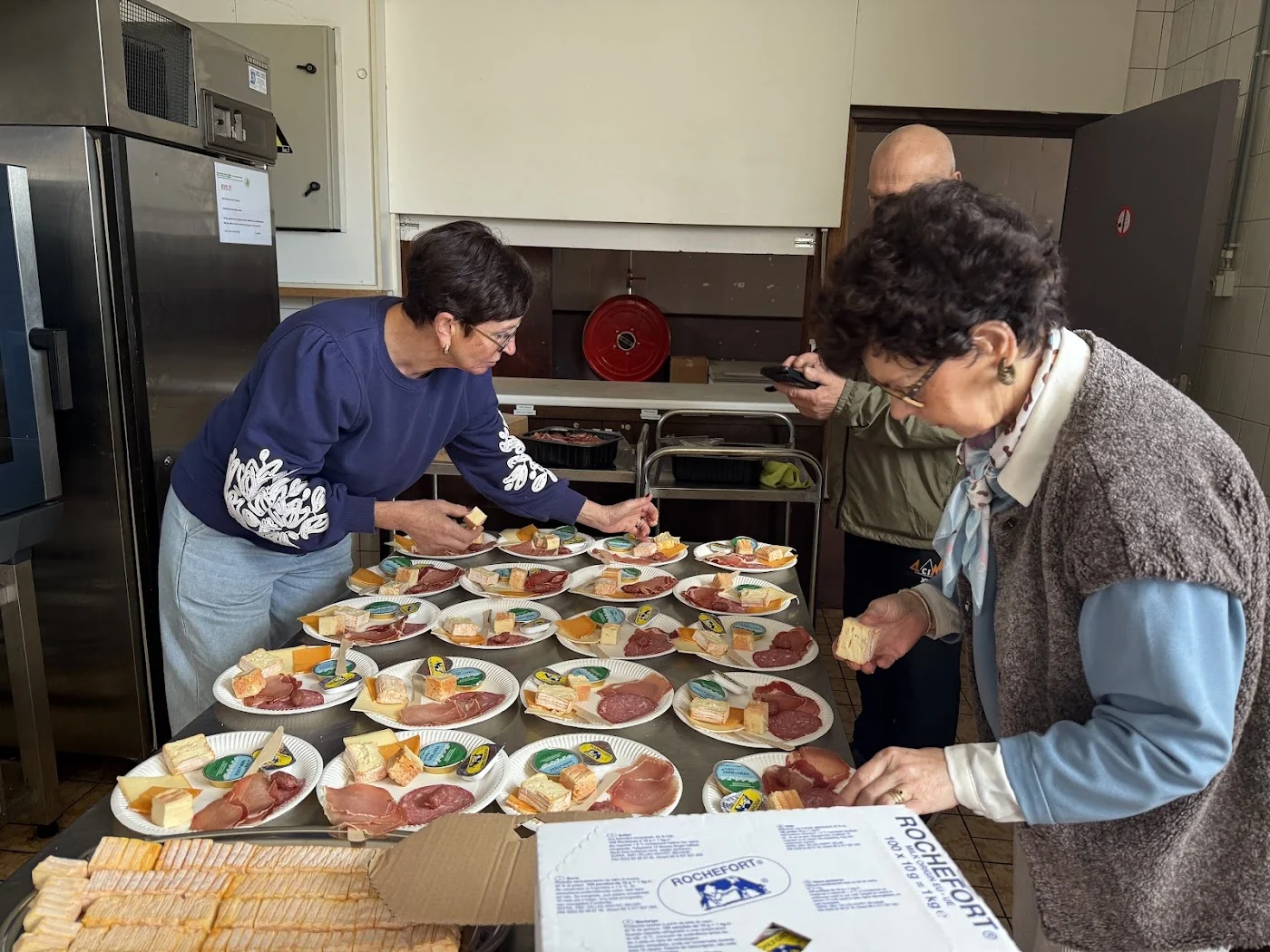 Des bénévoles préparent les assiettes du repas des 4 Cimes