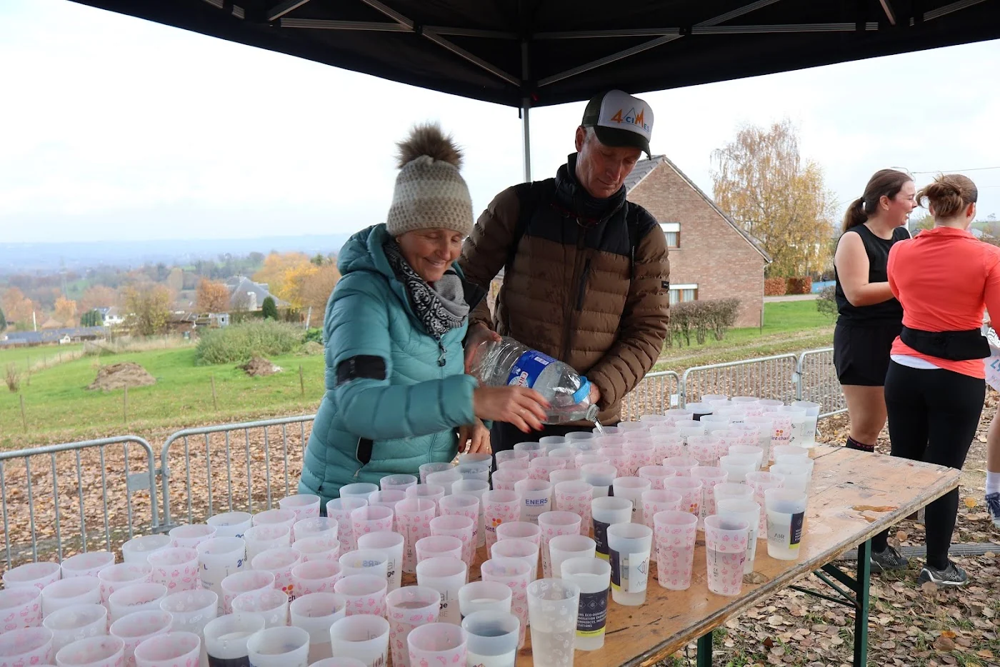 Des bénévoles préparent les boissons à un ravitaillement